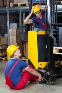 Two factory workers operating a fork lift.
