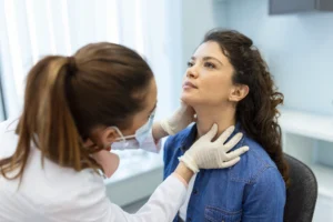 A doctor examining a patients neck.