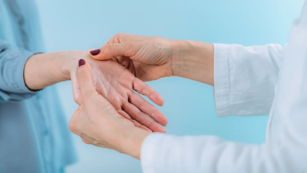 A doctor touching a person's wrist during an exam.