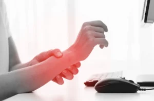 A person with a wrist injury holding their injured hand.